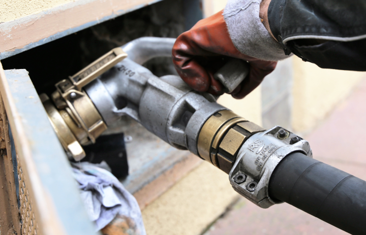 Prime Oil driver filling a home heating oil tank fill pipe